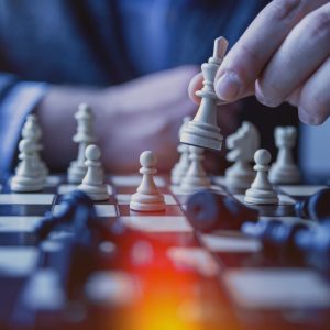 Man moving chess piece on chess board