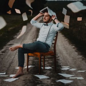 Man holding book to head to divine an answer